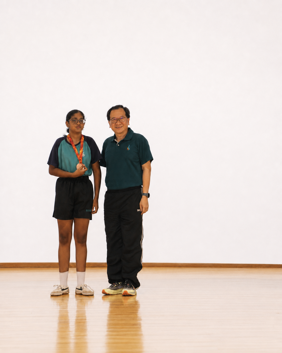 a girl with a medal stands next to the principal